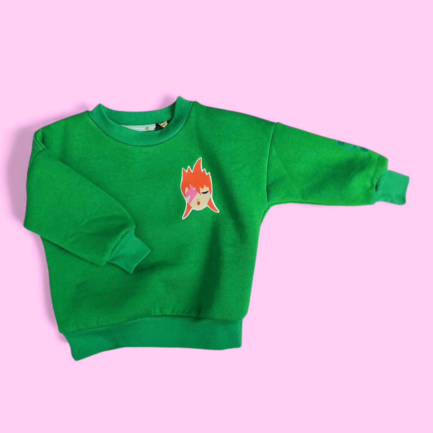 sweat  vert avec écusson appliqué Ziggy à plat sur fond rose